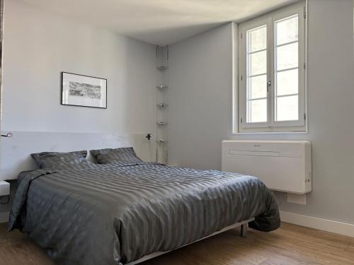 une chambre blanche avec un lit et une fenêtre dans l'établissement New - Charming apartment - historic heart, à Montpellier