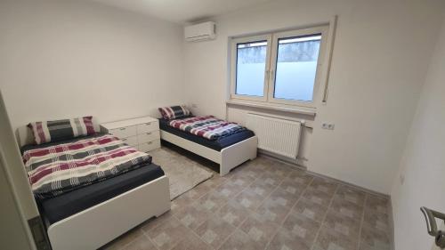 ein Schlafzimmer mit zwei Betten und einem Fenster in der Unterkunft Urlaub am Rhein Speyer Hockenheim Mannheim in Altlußheim
