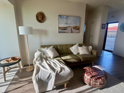 a living room with a couch and a table at The Seaview at Semaphore Park in Port Adelaide