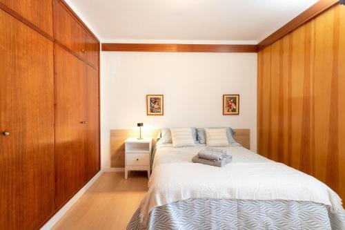 ein Schlafzimmer mit einem großen Bett und einer Holzwand in der Unterkunft Secrets of Montserrat in El Bruc