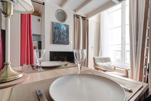een eettafel met twee wijnglazen erop bij Charming Studio - 2P - Sentier Montorgueil in Parijs