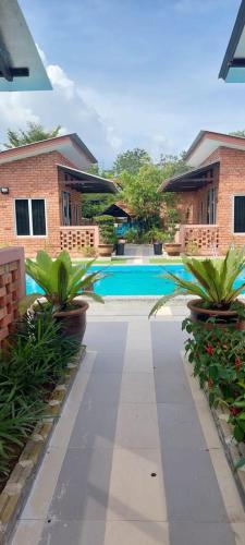 a walkway in front of a house with plants at General's Lodge Staycation in Kampong Sungai Sembilang