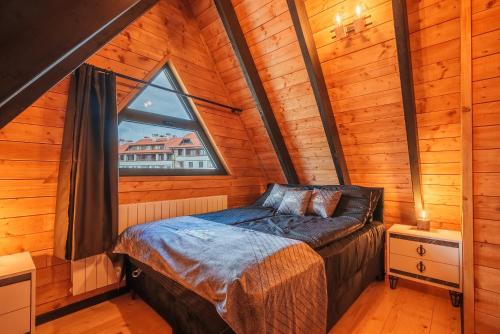 a bedroom in a log cabin with a bed and a window at Camping Bansko "Between the Mountains" in Bansko