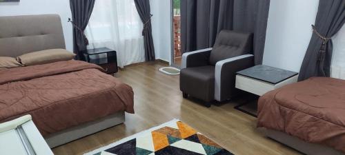 a bedroom with a bed and a chair and a couch at General's Lodge Staycation in Kampong Sungai Sembilang