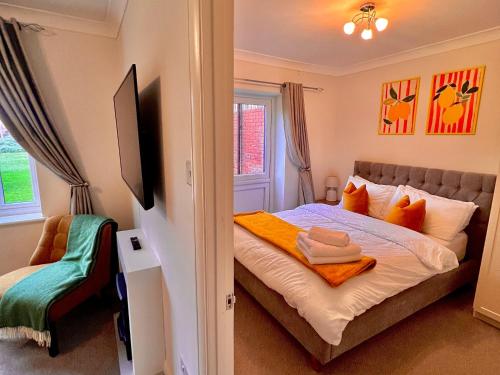 a bedroom with a bed with orange pillows and a window at Stylish 1 Bedroom Apartment with Free Parking and Links to London & Essex in Stifford