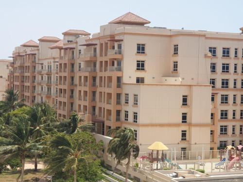 een groot gebouw met palmbomen ervoor bij زهور المدينة in King Abdullah Economic City