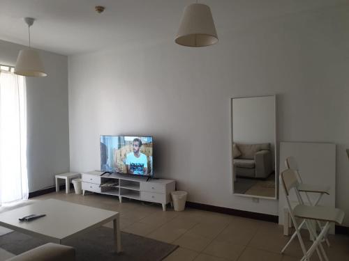 een woonkamer met een tv en een spiegel bij زهور المدينة in King Abdullah Economic City