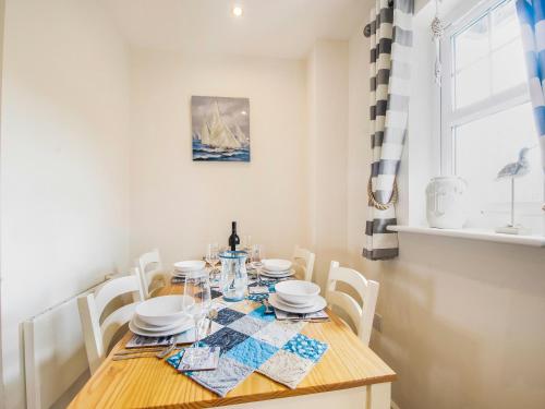 een eetkamer met een houten tafel en stoelen bij Harbour Retreat in Garlieston