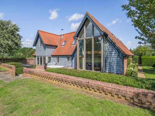 een huis met een groot raam aan de zijkant bij Wittle Cottage in Quidenham
