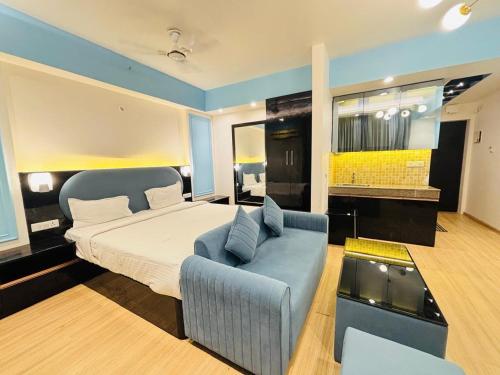 a bedroom with a bed and a blue couch at Hotel Four Season - Gomtinagar - Lucknow in Lucknow