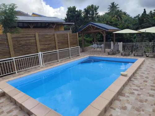 a swimming pool at a resort with a blue pool at Studio moderne près de Capesterre-Belle-Eau avec piscine in Capesterre-Belle-Eau