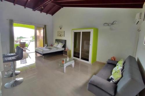 een woonkamer met een bank en een tafel bij Studio moderne près de Capesterre-Belle-Eau avec piscine in Sainte-Marie des Bois