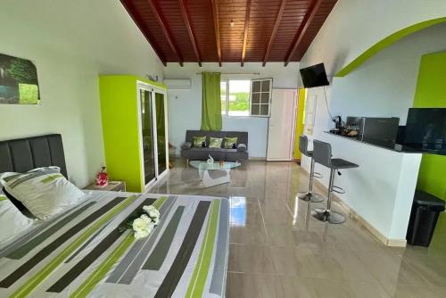 a bedroom with a bed and a living room at Studio moderne près de Capesterre-Belle-Eau avec piscine in Capesterre-Belle-Eau