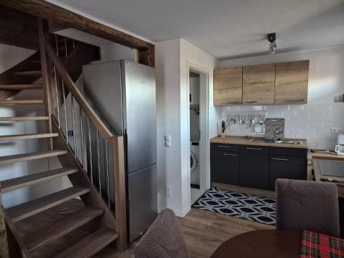 une cuisine avec un réfrigérateur en acier inoxydable et un escalier dans l'établissement Haus an der Dorfteichstraße, à Alt Krenzlin