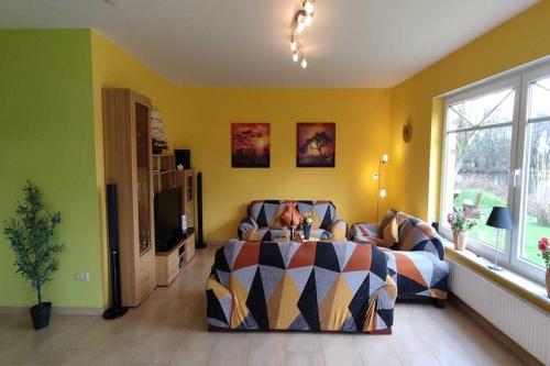 a bedroom with a bed and a couch and a tv at Apartment house at Kiessee, Westerholt in Westerholt