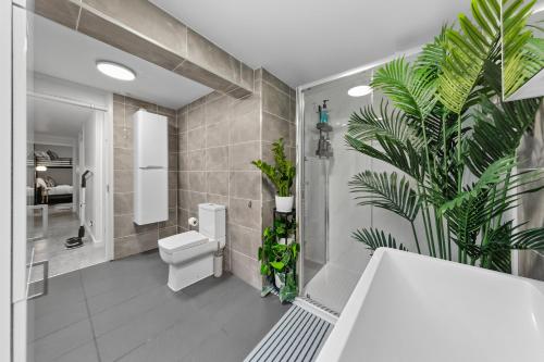 a bathroom with a toilet and plants on the wall at New Modern Hybrid 4 Bedrooms 7 Bed apartment 12 guest capacity in London