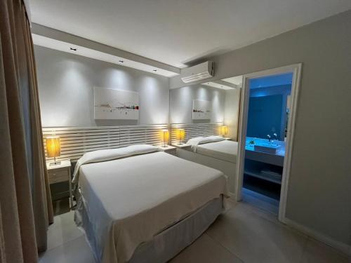 a hotel room with two beds and a bathroom at MC FLATS IPANEMA BEACH STAR in Rio de Janeiro
