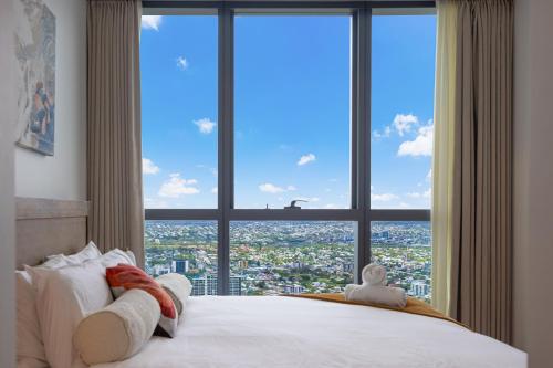a bedroom with a large window with a city view at Luxury 50th Floor 2BR at Queens Wharf with Parking in Brisbane