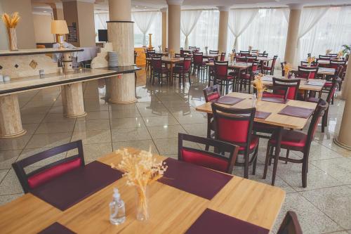 a dining room with tables and chairs in a restaurant at Grande Hotel Guarapuava in Guarapuava