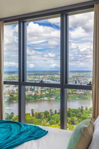 a bedroom with a large window overlooking a river at Luxury 50th Floor 2BR at Queens Wharf with Parking in Brisbane