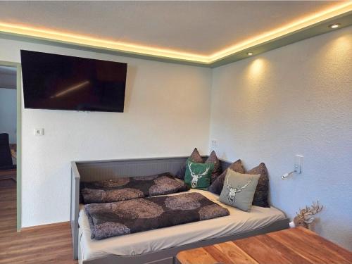 a room with a bed with pillows and a tv at Apartment am Egghof Deluxe in Oberperfuss