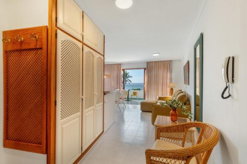 einen Flur, der zu einem Wohnzimmer mit einem Tisch und Stühlen führt in der Unterkunft Playa Delphin 205 in Puerto Naos
