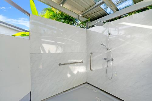 a bathroom with a shower with a glass wall at Eden House Kewarra Beach in Kewarra Beach