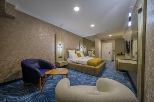 a hotel room with a bed and two chairs at HanzadeHotel in Edremit