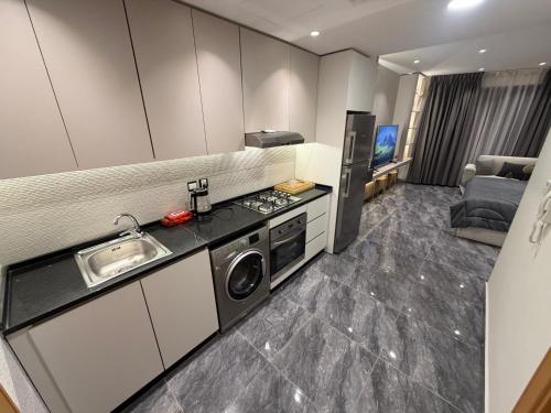 uma pequena cozinha com pia e geladeira em ستديو فندقي برج داماك بوليفارد العبدلي em Amã