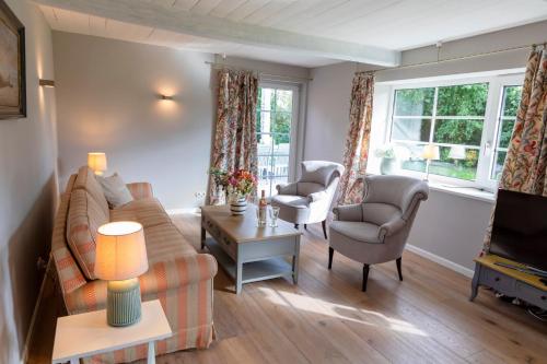 a living room with a couch and two chairs and a tv at Ferienwohnung Steuerbord Steinbergkirche in Steinbergkirche