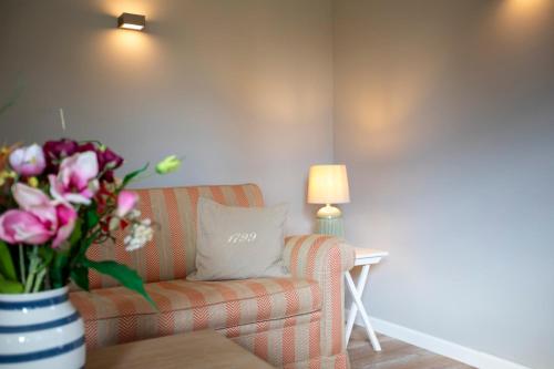 a living room with a couch and a vase of flowers at Ferienwohnung Steuerbord Steinbergkirche in Steinbergkirche