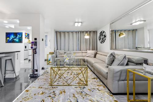 a living room with a couch and a table at New Modern Hybrid 4 Bedrooms 7 Bed apartment 12 guest capacity in London