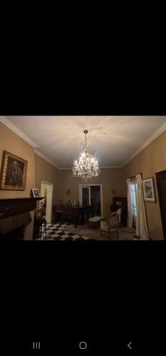 salon z żyrandolem zwisającym z sufitu w obiekcie Oasis Colonial w mieście Asunción