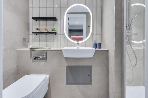 a white bathroom with a sink and a mirror at The Bonnie in Glasgow
