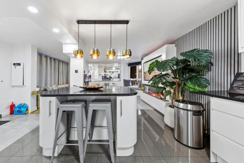a kitchen with a black counter and stools at New Modern Hybrid 4 Bedrooms 7 Bed apartment 12 guest capacity in London