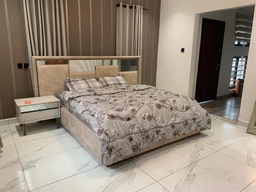 ein Schlafzimmer mit einem großen Bett mit einer Decke in der Unterkunft Pearlmab villa in Tema