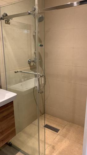 eine Glasdusche im Bad mit Waschbecken in der Unterkunft Pearlmab villa in Tema