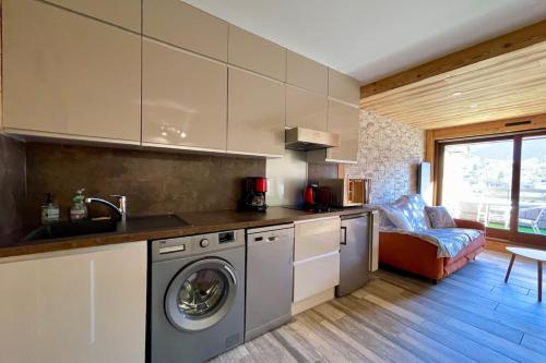 Una cocina con lavadora y secadora en una habitación. en Beautiful studio with magnificent view, en Briançon