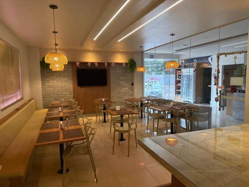 马卡帕诺特酒店的配有木桌椅和平板电视的餐厅