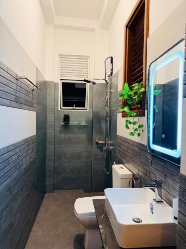 a bathroom with a toilet and a sink and a shower at Sunset Villa in Dickwella