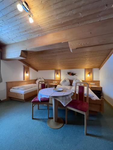 a bedroom with a bed and a table and chairs at Badmeisterhof in Leogang