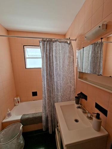 a bathroom with a shower curtain and a sink at Los Dias de Viaje in Tandil