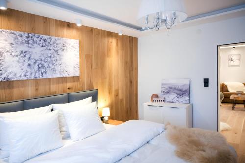 a bedroom with a white bed and a painting on the wall at NĀVA PLACE Cozy home in Kaprun in Kaprun