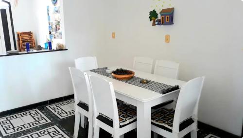 a white table with white chairs and a plant on it at Um castelo só pra você! 