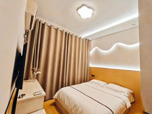 毕节Good dream Hotel的一间卧室，配有一张床和一张带电视的桌子