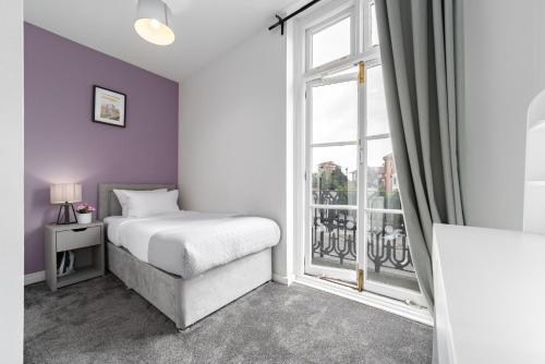 a bedroom with a bed and a large window at Harbour Hub Hotel in Southampton