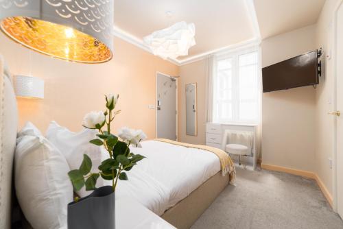 a bedroom with a bed and a vase with flowers at Harbour Hub Hotel in Southampton
