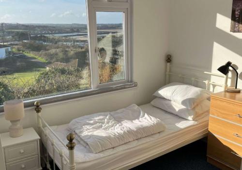 ein Schlafzimmer mit einem Bett und einem Fenster mit Aussicht in der Unterkunft D39 St Margarets, Riviere Towans in Hayle