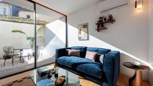 a living room with a blue couch and a table at Ando Living - São Miguel House in Porto
