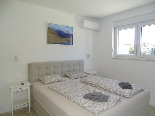 a white bedroom with two beds and a window at More i Sol Rab Pool House in Rab